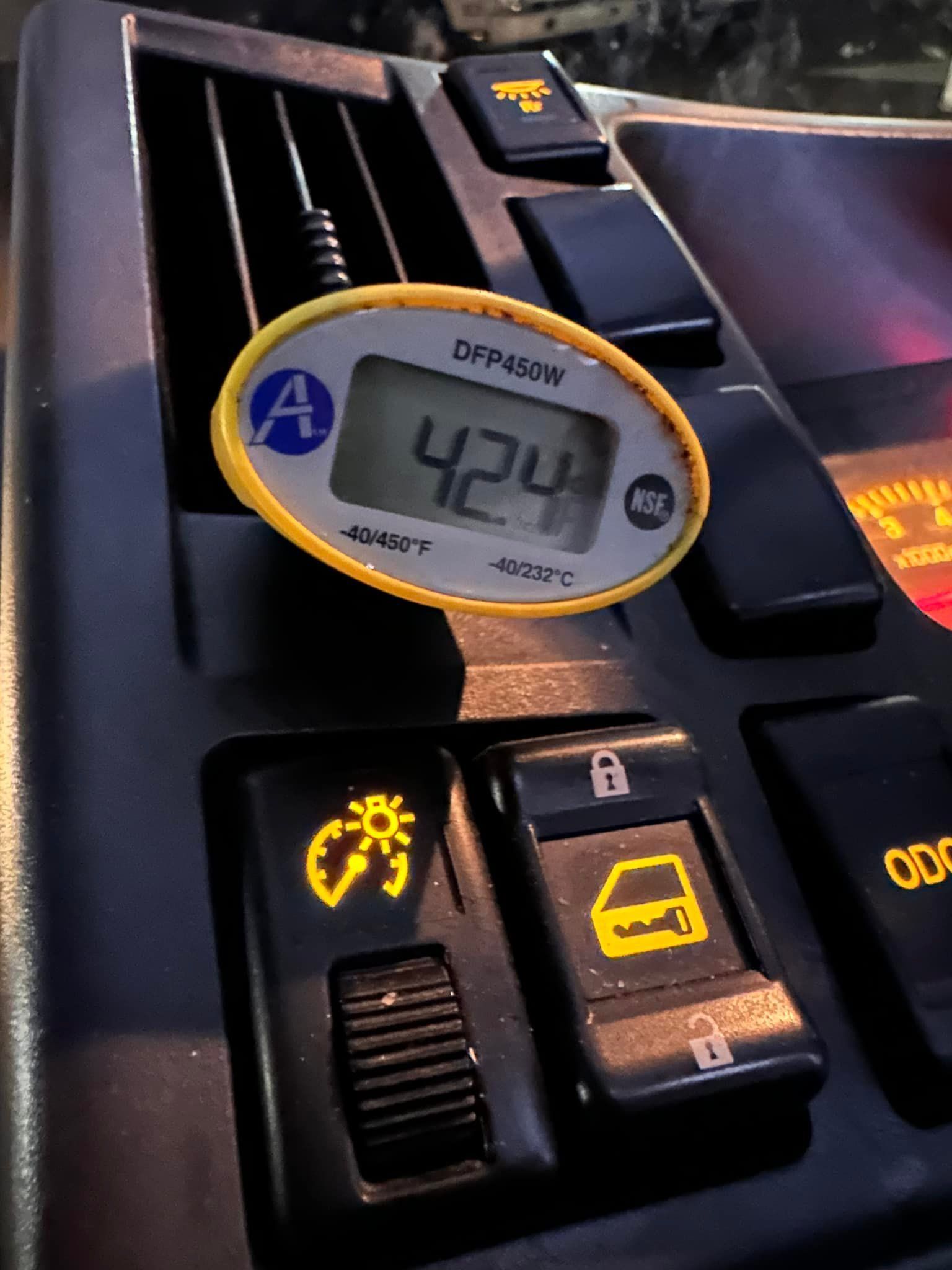 Dashboard with digital thermometer reading 42.4; buttons for lights and door locks are visible.