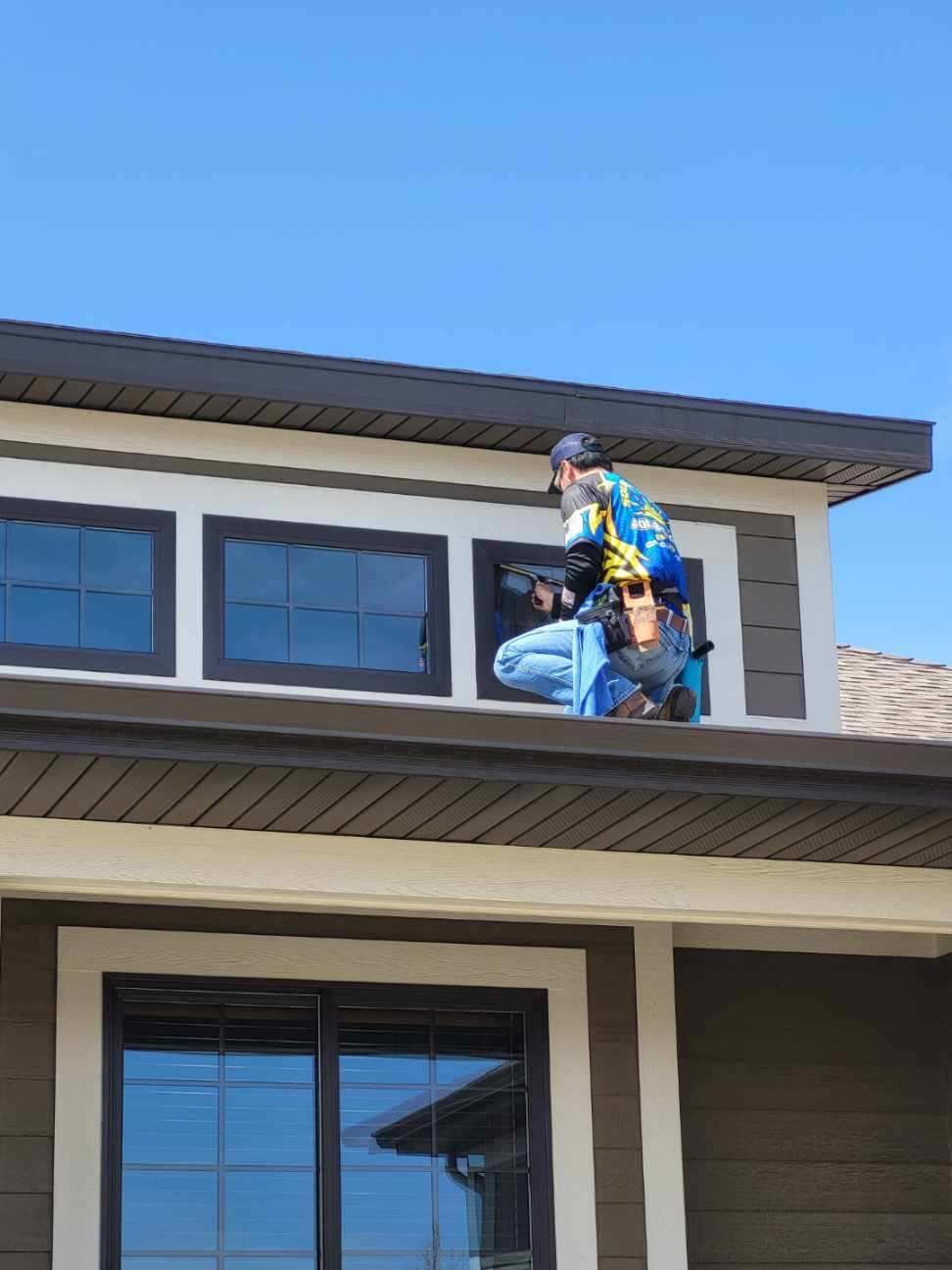 A man is working on the roof of a house