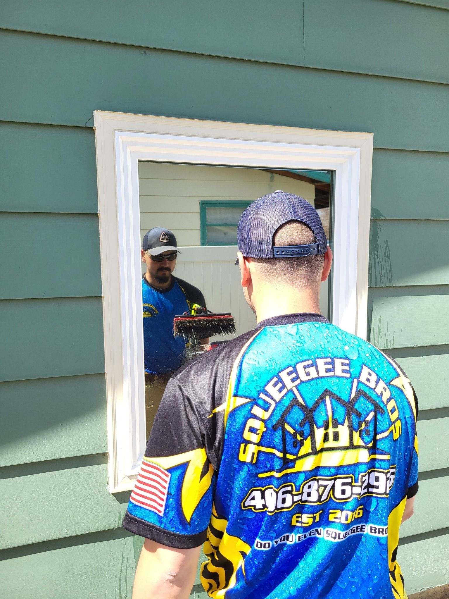 A man wearing a shirt that says squeegee on it