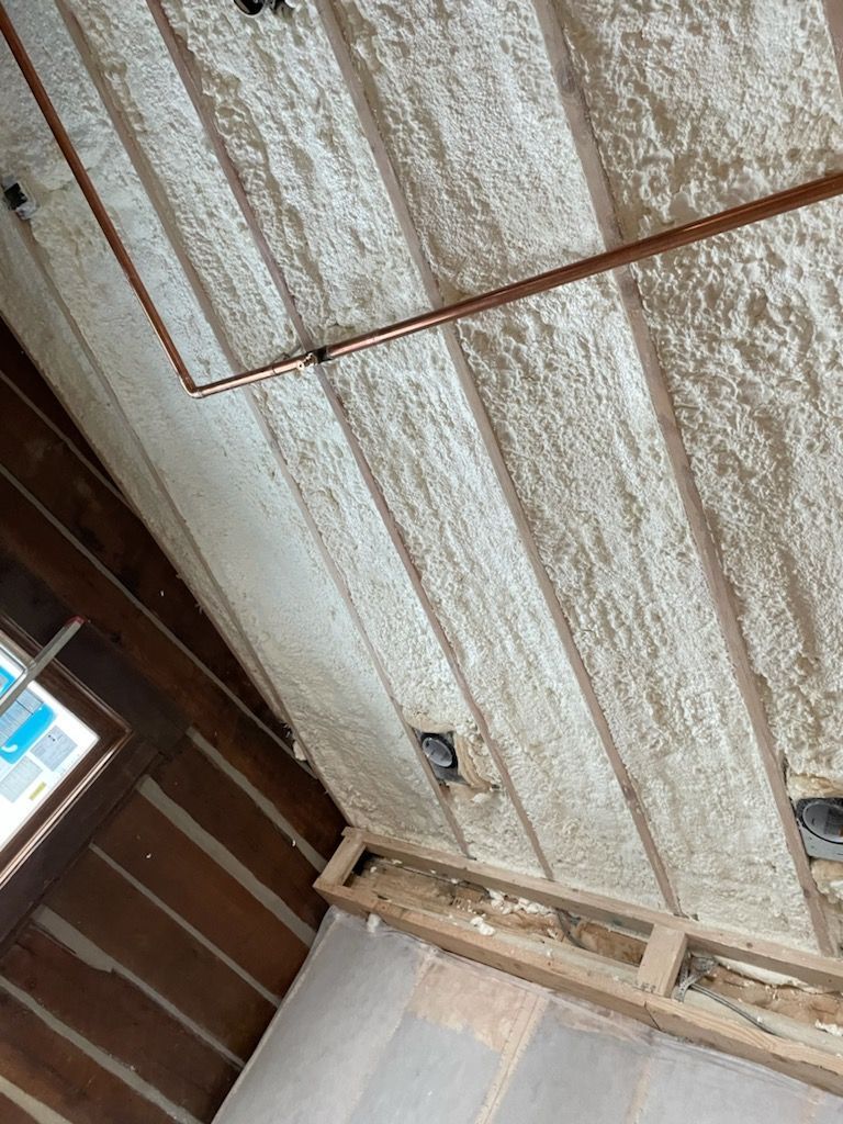 Corroded metal ceiling panels with rust and a small window in a wooden room
