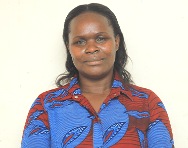 A woman in a blue and red shirt is smiling for the camera.