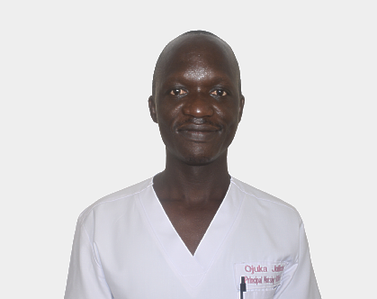 A man in a white scrub top is smiling for the camera.