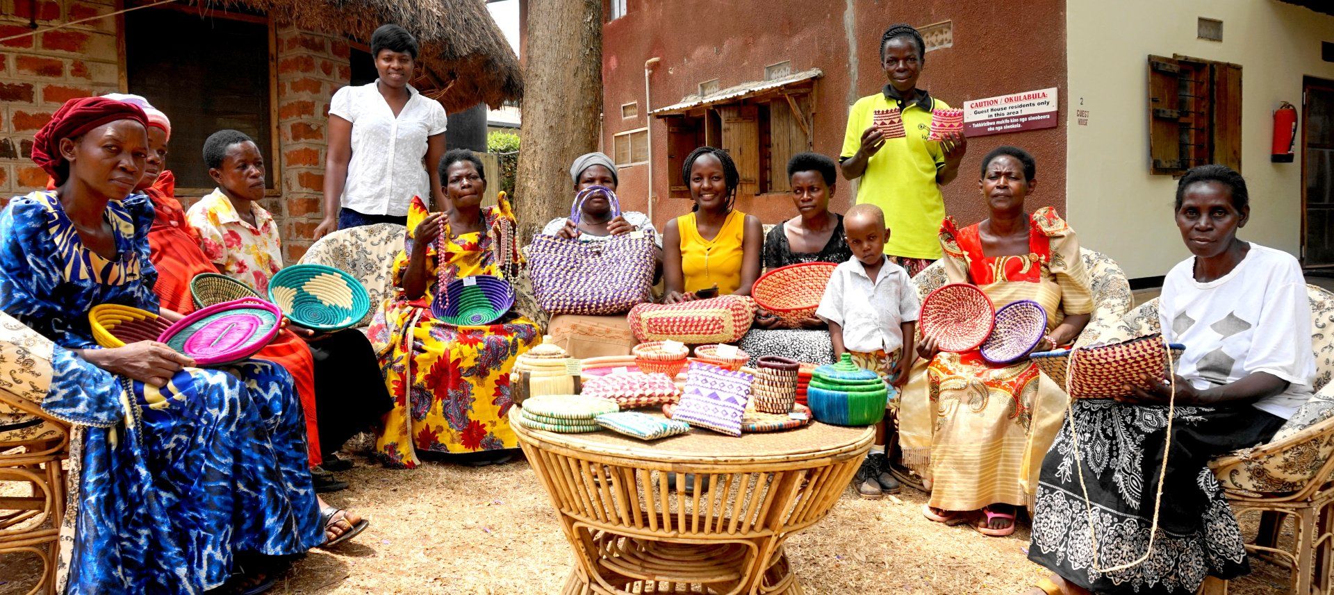 A group of people are sitting around a table with baskets on it.