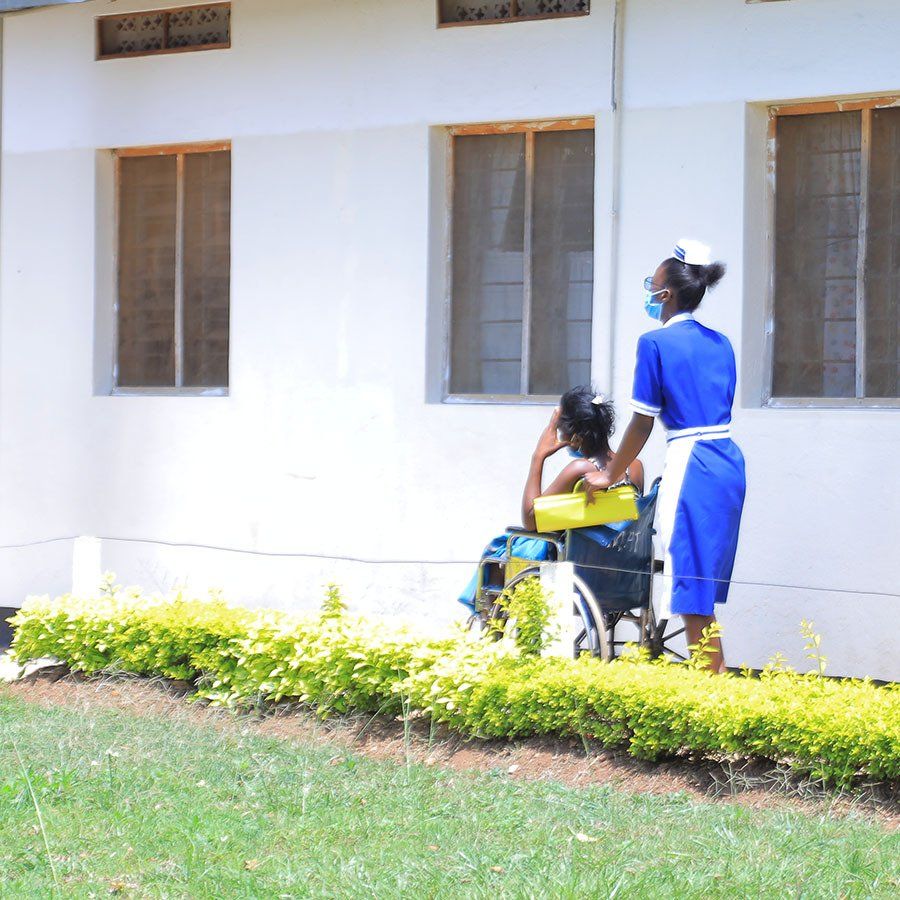 A woman in a wheelchair is talking to a nurse