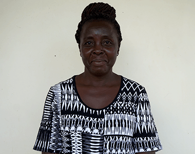 A woman in a black and white shirt is smiling for the camera.