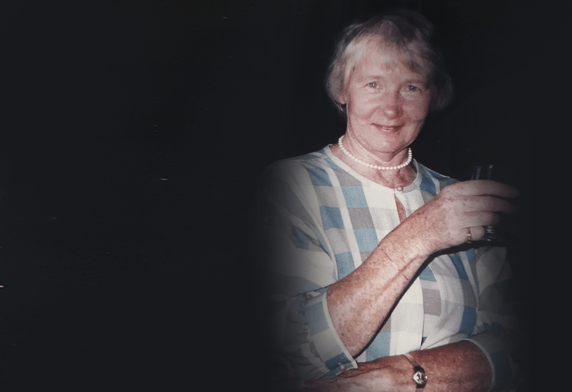 A woman is holding a glass of wine in her hand.