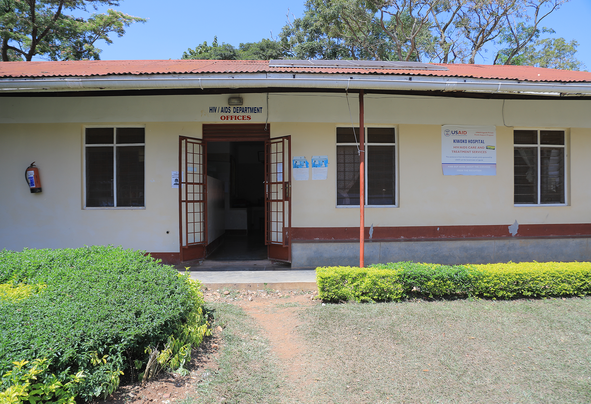 A white building with a red roof and a sign that says ' office ' on it