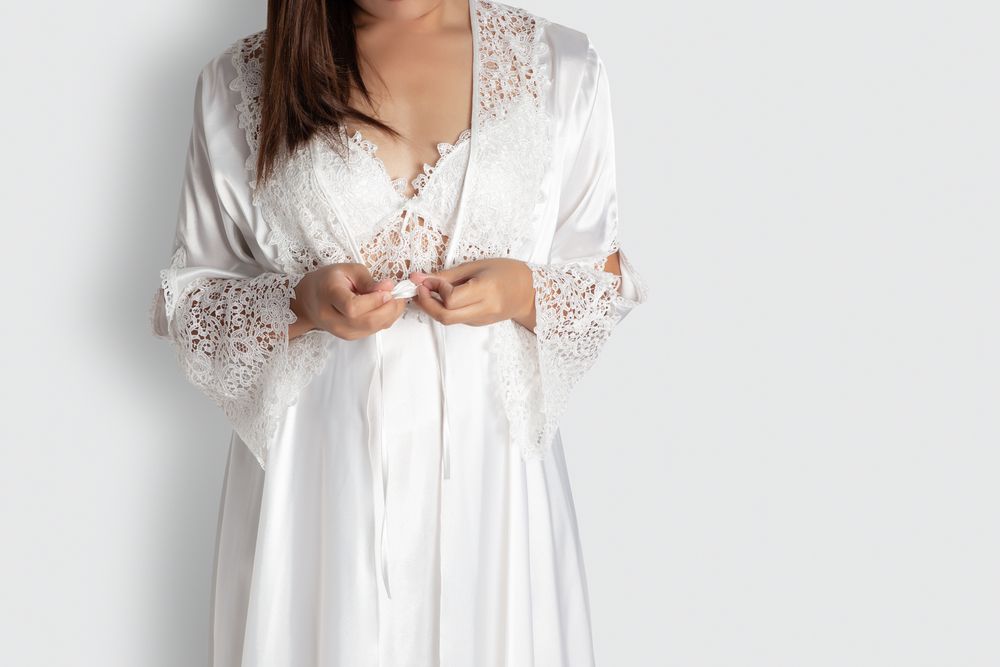 Woman in White Lingerie and Robe Adjusting Tie — Shona's Lingerie in Hermit Park, QLD
