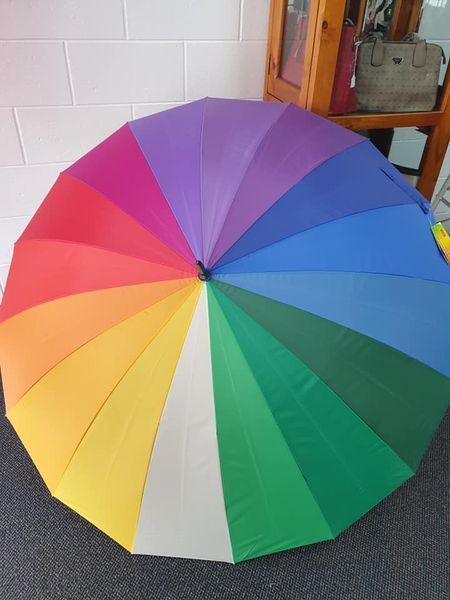 Opened Rainbow-coloured Umbrella on a Dark Surface, Against a Light-coloured Wall — Shona's Lingerie in Hermit Park, QLD