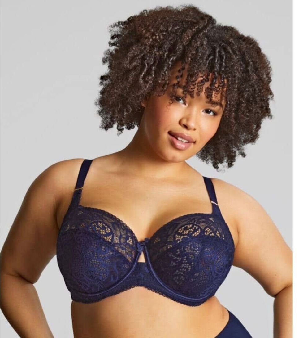 Woman Modeling a Navy Lace Bra, Smiling Against a Light Gray Background — Shona's Lingerie in Hermit Park, QLD
