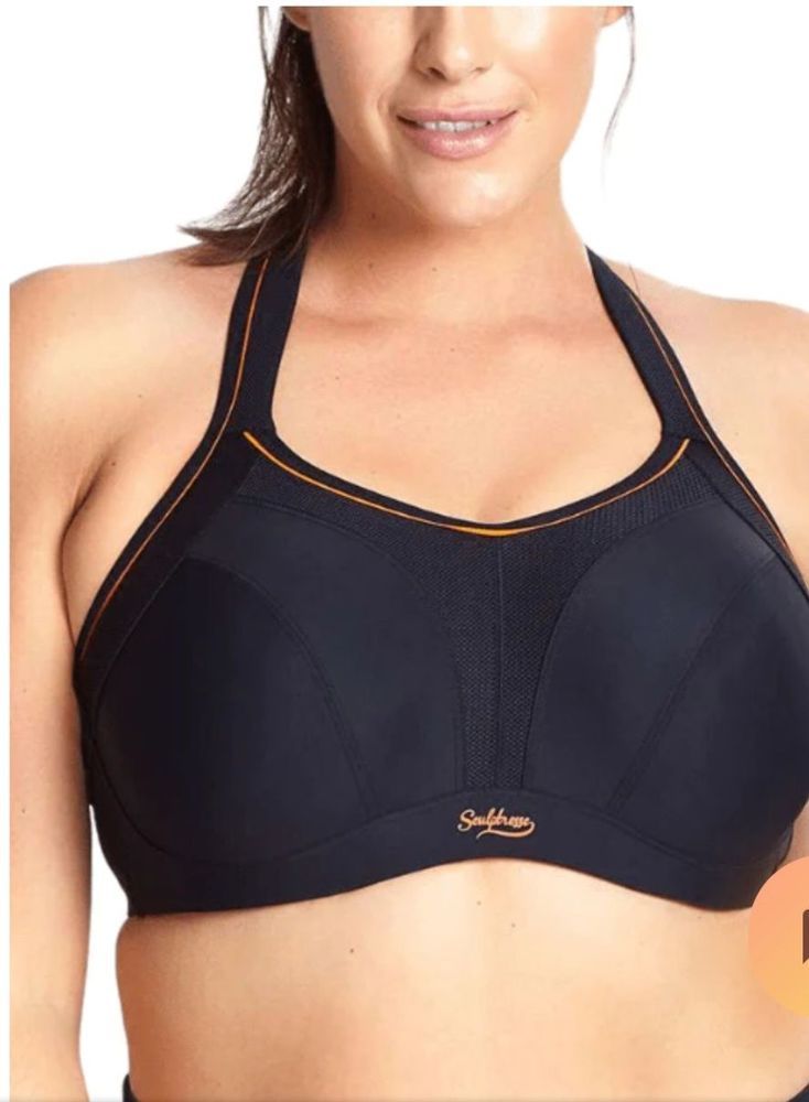 Woman Wearing a Black Sports Bra With Orange Trim, Smiling Slightly — Shona's Lingerie in Hermit Park, QLD