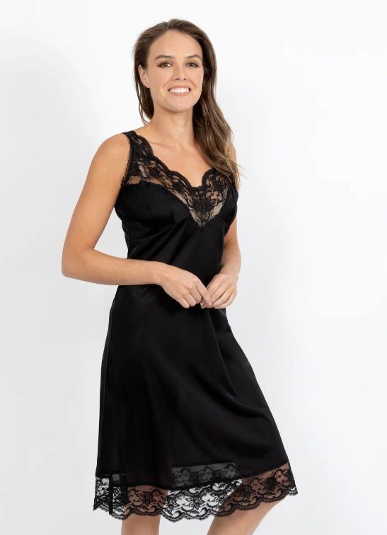 Woman Wearing a Black Slip Dress With Lace Trim, Smiling, Indoors — Shona's Lingerie in Hermit Park, QLD