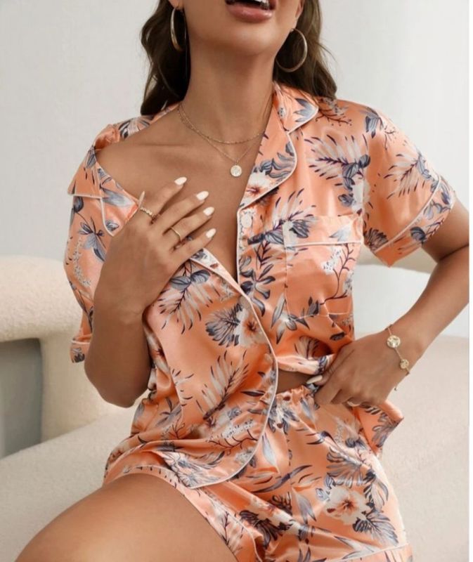 Woman Wearing Peach Floral Pajama Set, Smiling, Sitting — Shona's Lingerie in Hermit Park, QLD