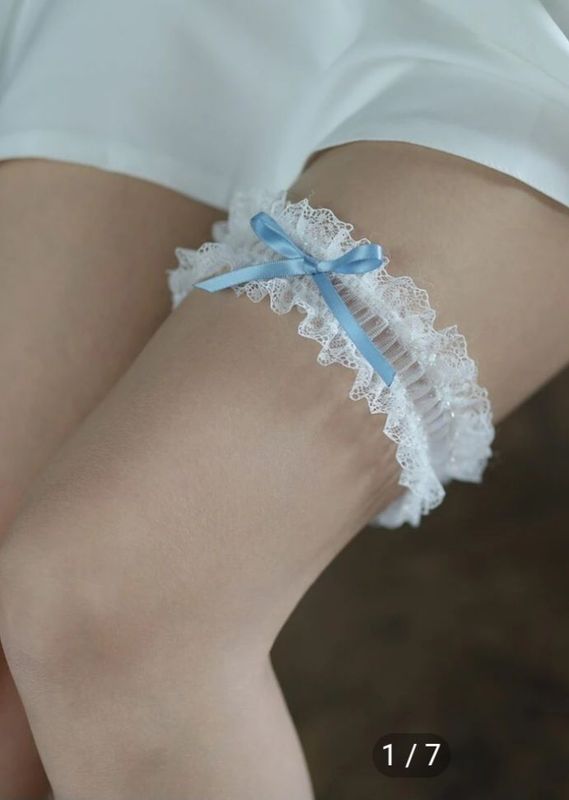 White lace garter with light blue bow on a leg — Shona's Lingerie in Kirwan, QLD.
