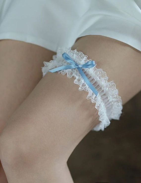 White lace garter with light blue bow on a person's thigh. - Shona's Lingerie, Townsville, QLD.