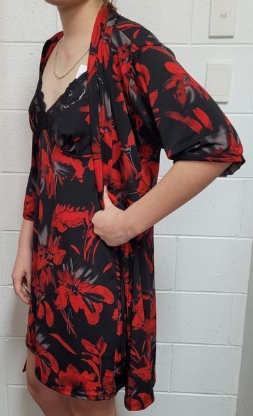 Person in Red Floral Dress and Cardigan, Hand on Hip, Standing Near White Wall — Shona's Lingerie in Hermit Park, QLD
