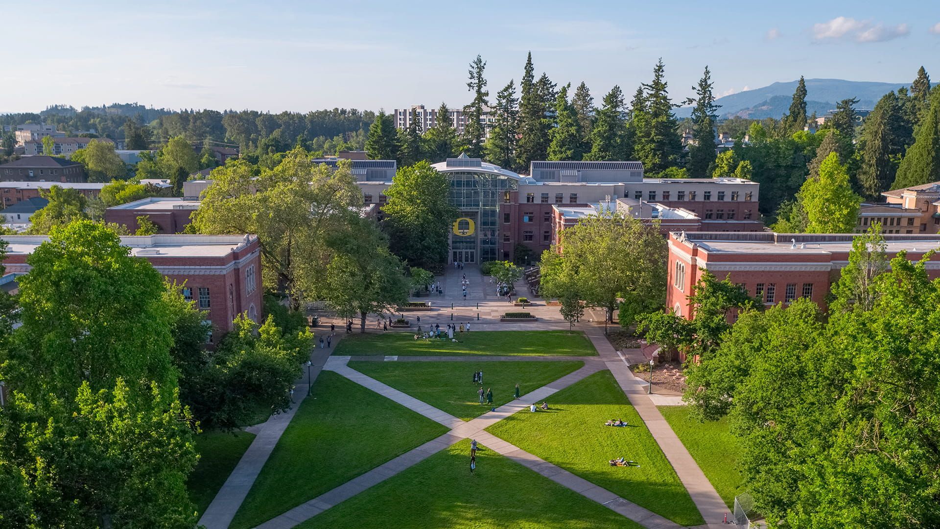 The University of Oregon campus with green grass, trees, and brick building