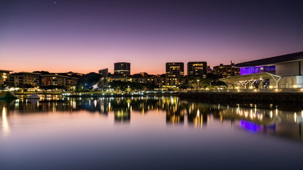 A City Is Reflected in The Water at Night — Austar Underground Services in Darwin, NT
