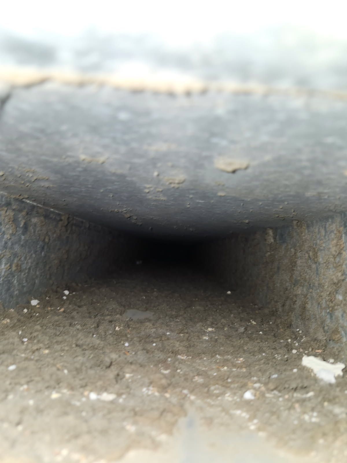 Dark rectangular vent, dirty with debris, receding into darkness.
