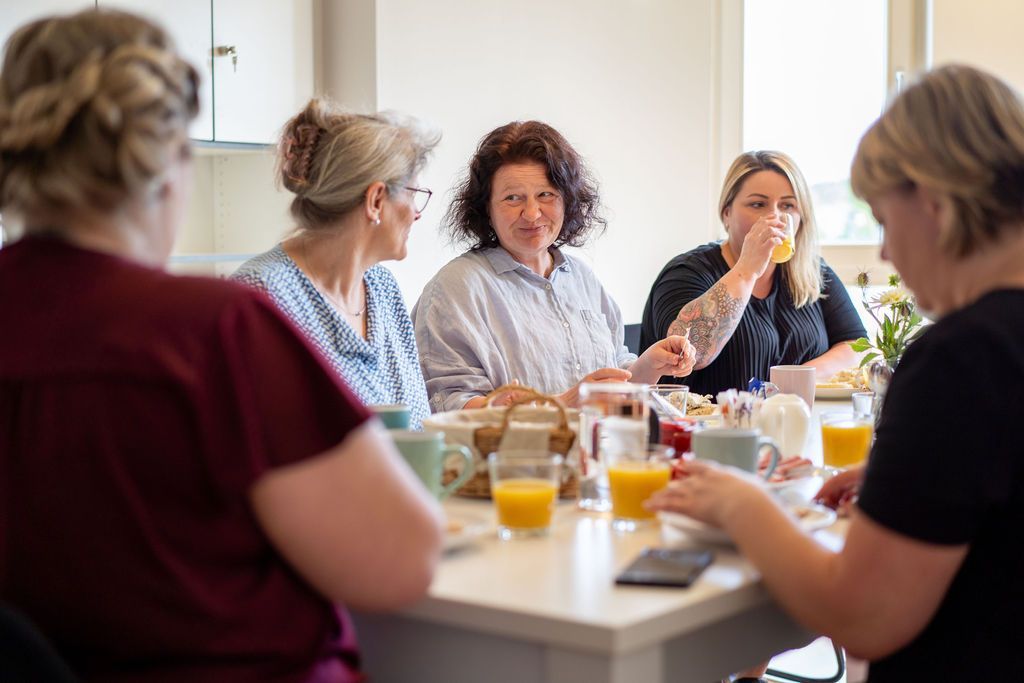 Mitarbeiter sitzen zum Frühstücken am Tisch