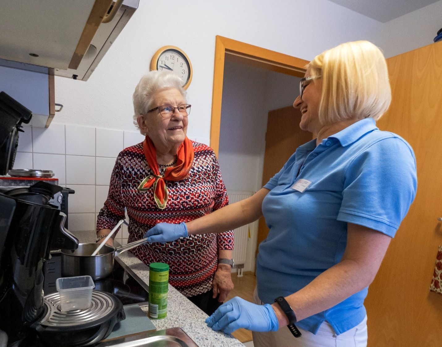 Hauswirtschaftskraft putzt Küche einer Seniorin.