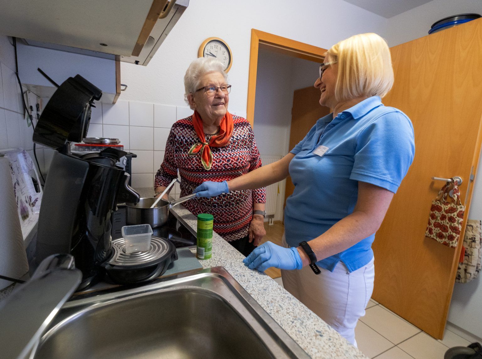 Hauswirtschaftskraft putzt Küche einer pflegebedüftigen Dame