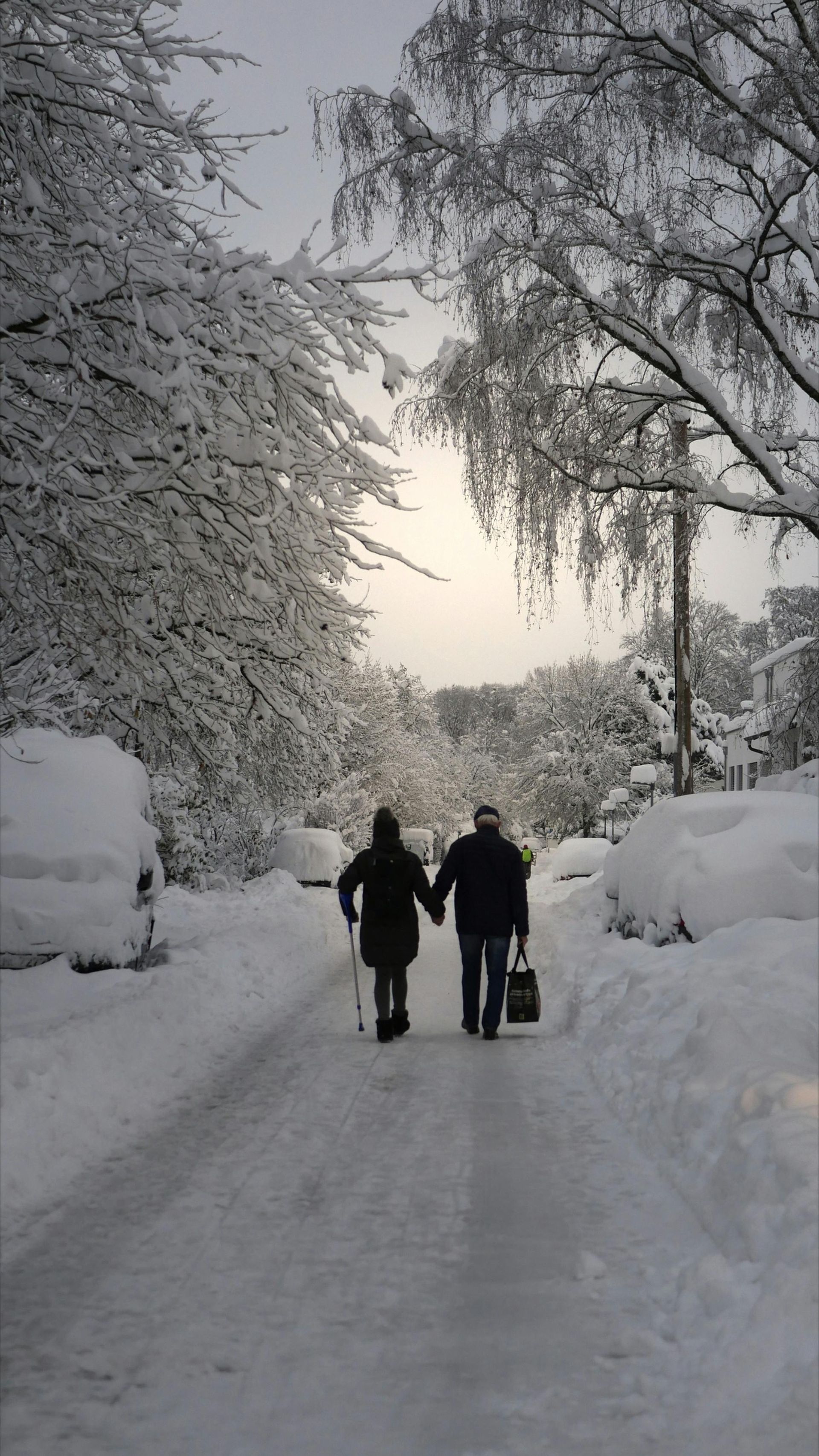 Zwei Senioren laufen durch den Schnee im Winter