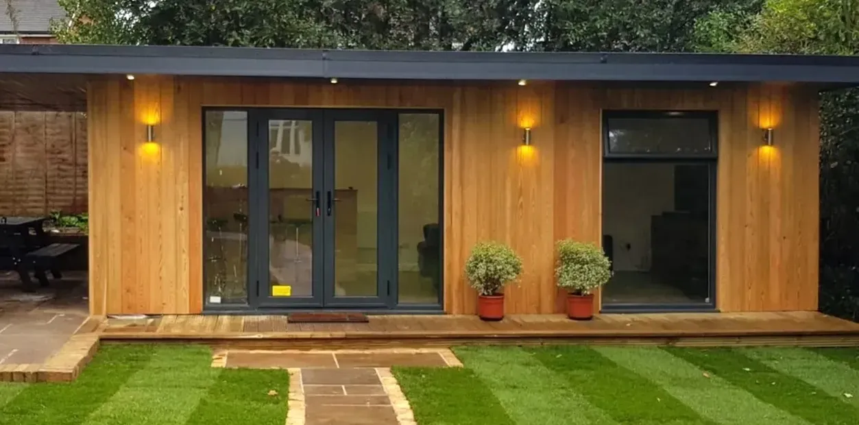 A Timber Garden Room is sitting on top of a lush green lawn.