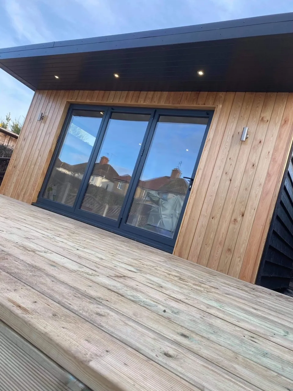A Timber Garden Room with sliding glass doors and a wooden deck.
