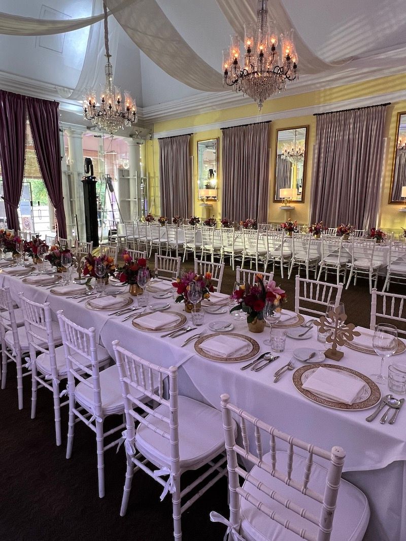 A large room with tables and chairs set up for a wedding reception.