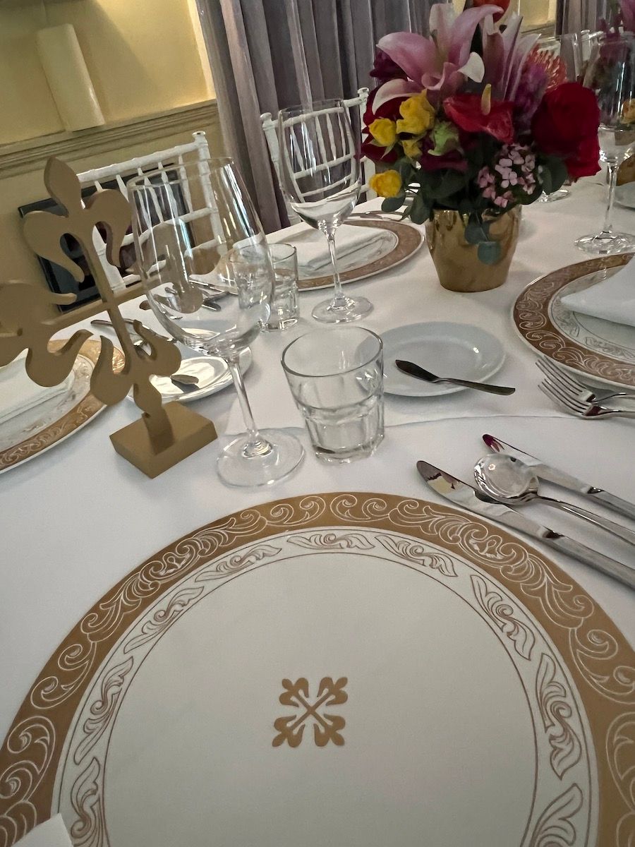 A table with plates , glasses , utensils and flowers on it.