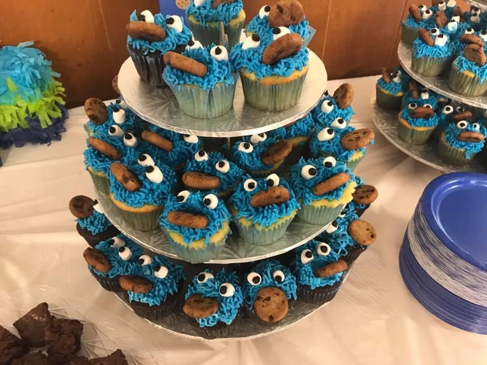 Cookie Monster cupcakes on a tiered stand, blue frosting, chocolate cookies for eyes, brown