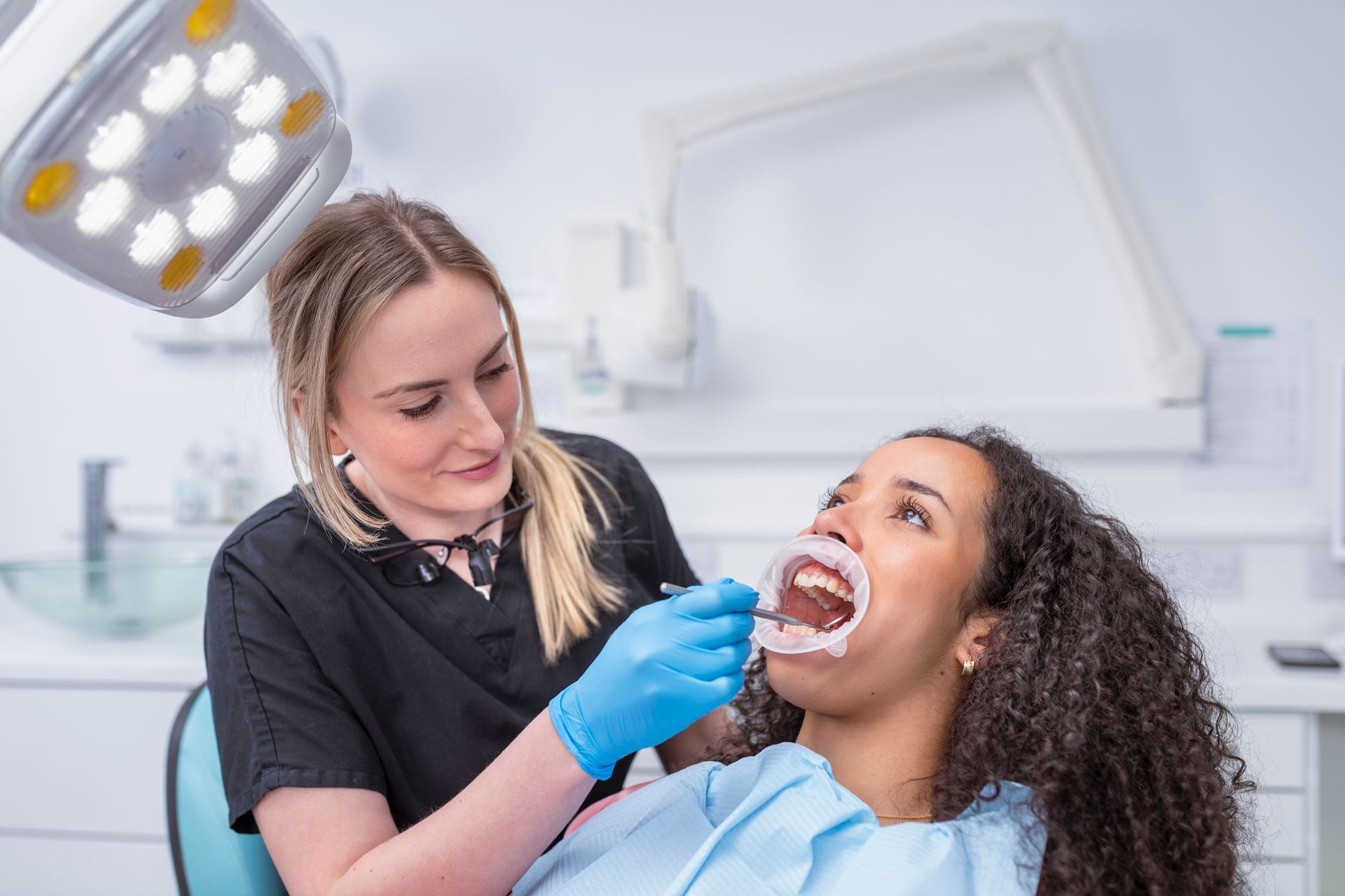 A dentist is checking a patient’s teeth.