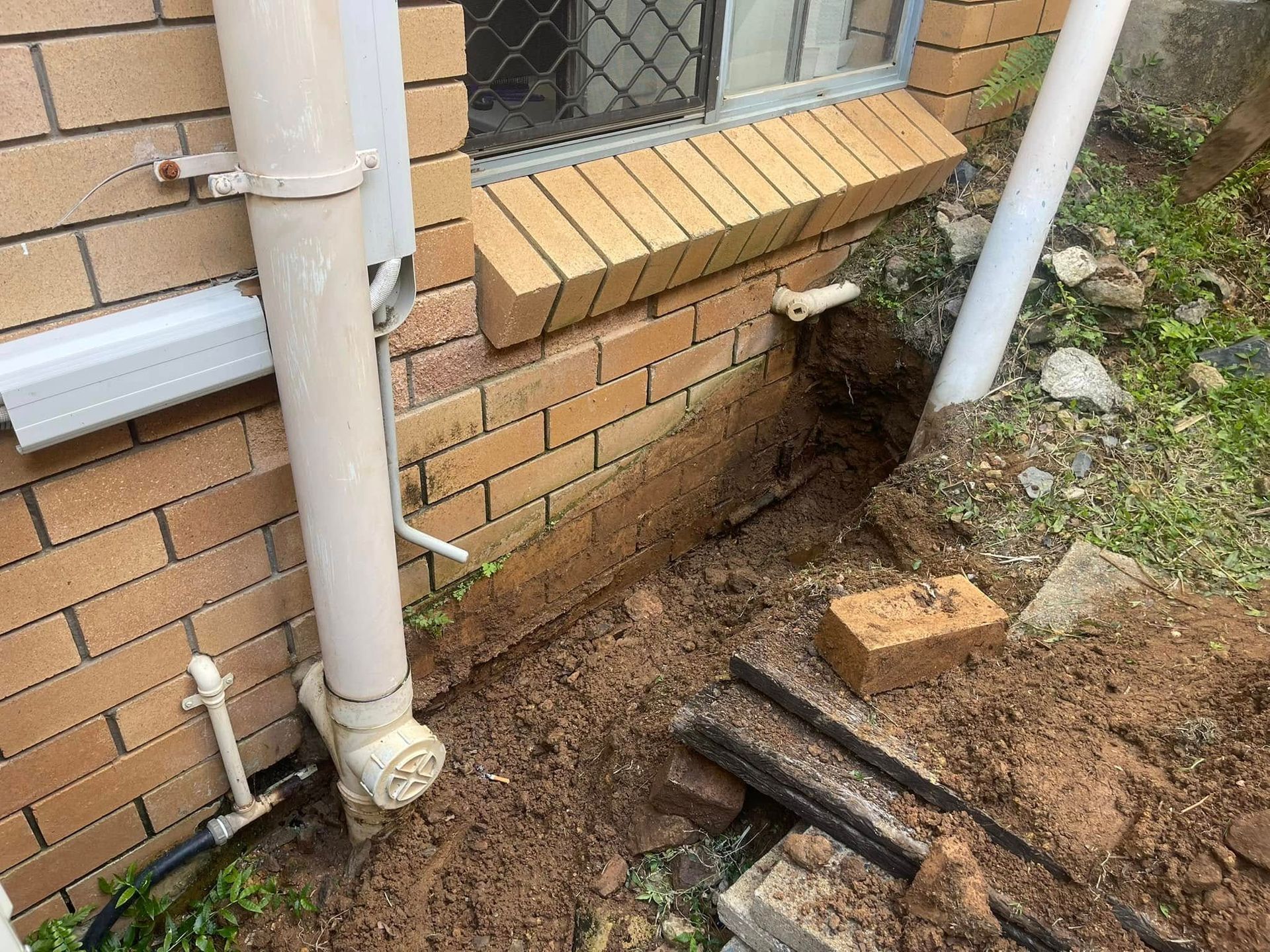 Person Cleans a Dark Gray Sink Filled — Hales Plumbing & Roofing In The Range, QLD