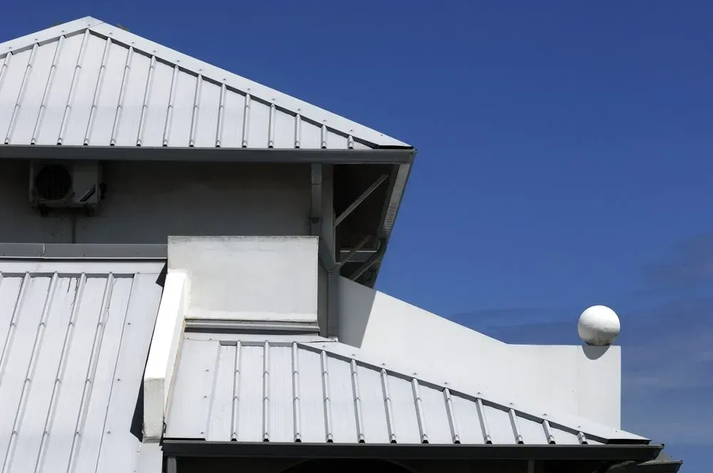A White House With A Chimney On The Roof And A Blue Sky In The Background — Residential Roofs in Toowoomba, QLD