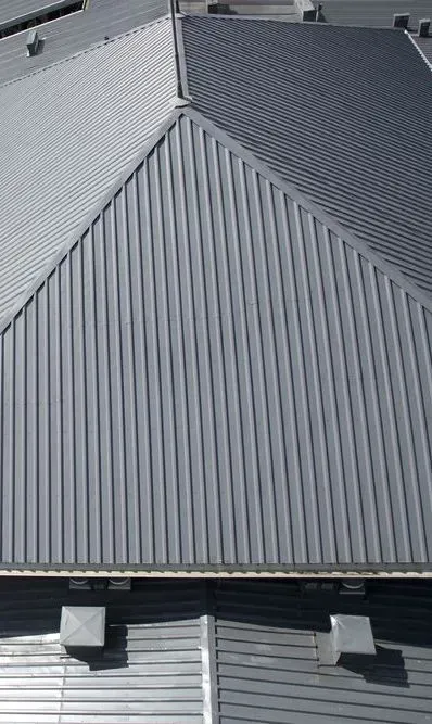 Two Construction Workers Are Working On The Roof Of A House — Roofer in Toowoomba, QLD