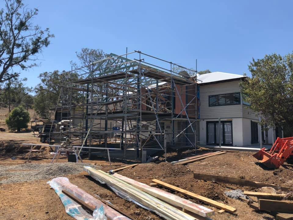 A House Roof Is Being Built With Scaffolding And Wood In Front Of It — Residential Roofs in Toowoomba, QLD