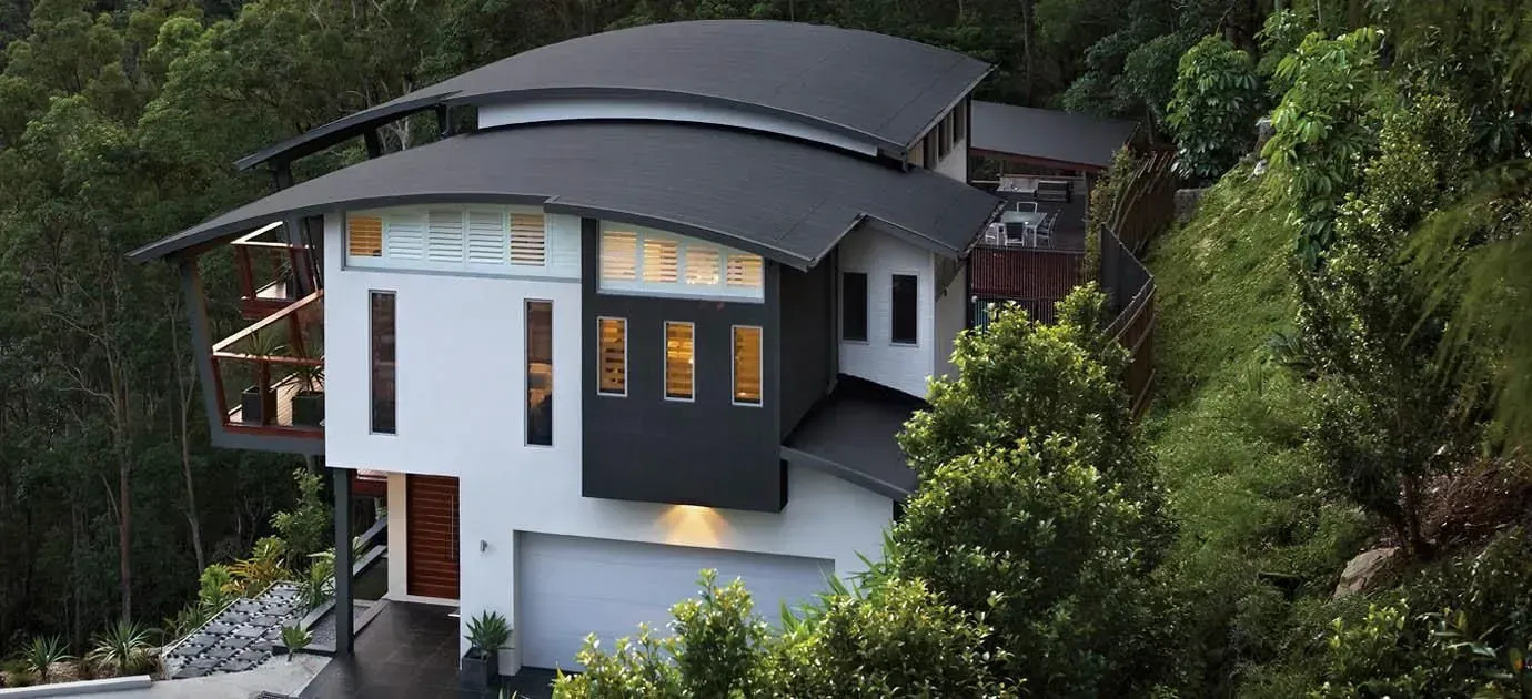 A Man Is Working On The Roof Of A House — Roofer in Toowoomba, QLD