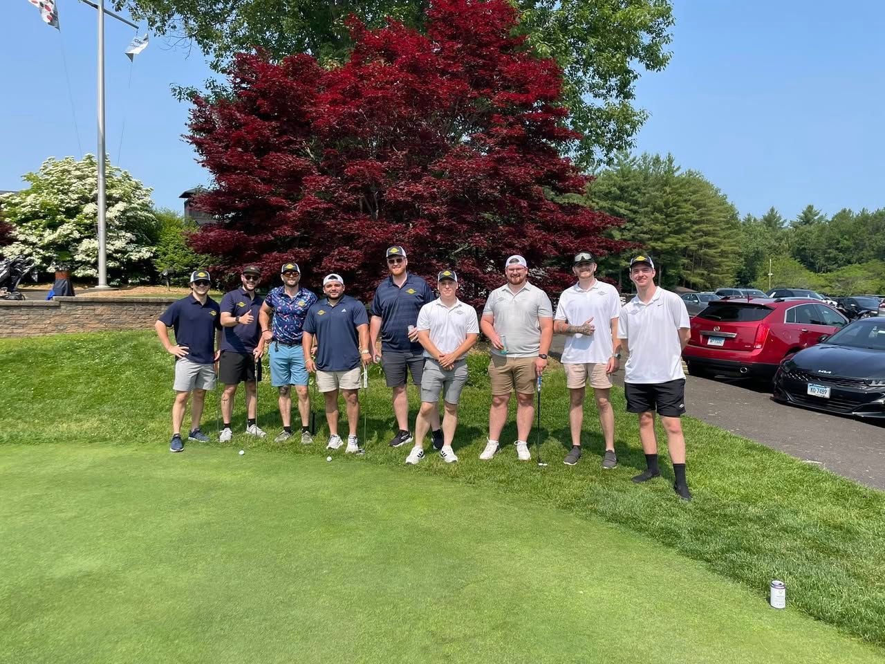 A group of men are posing for a picture on a golf course.