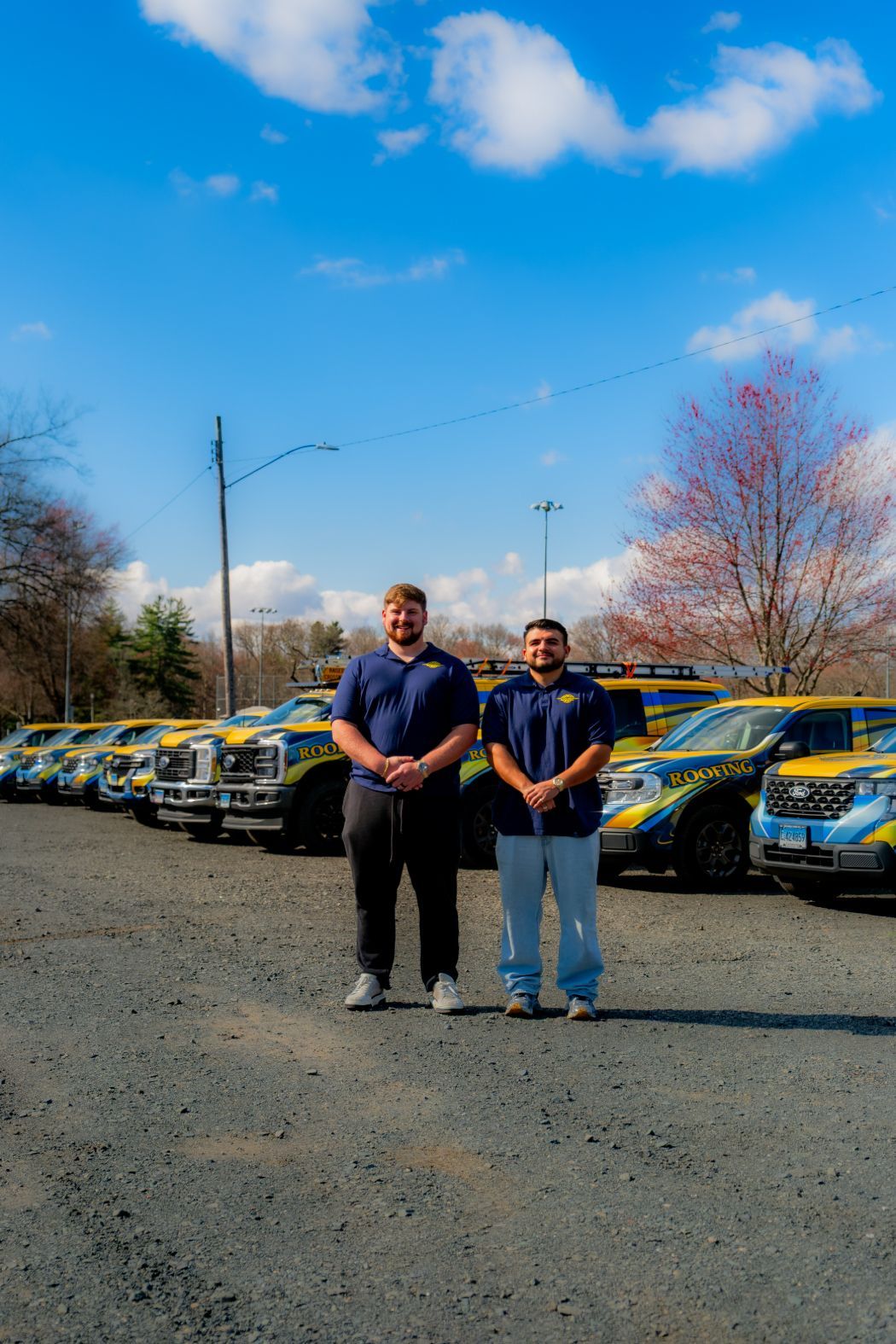 Two men standing in front of a row of yellow taxis under a blue sky