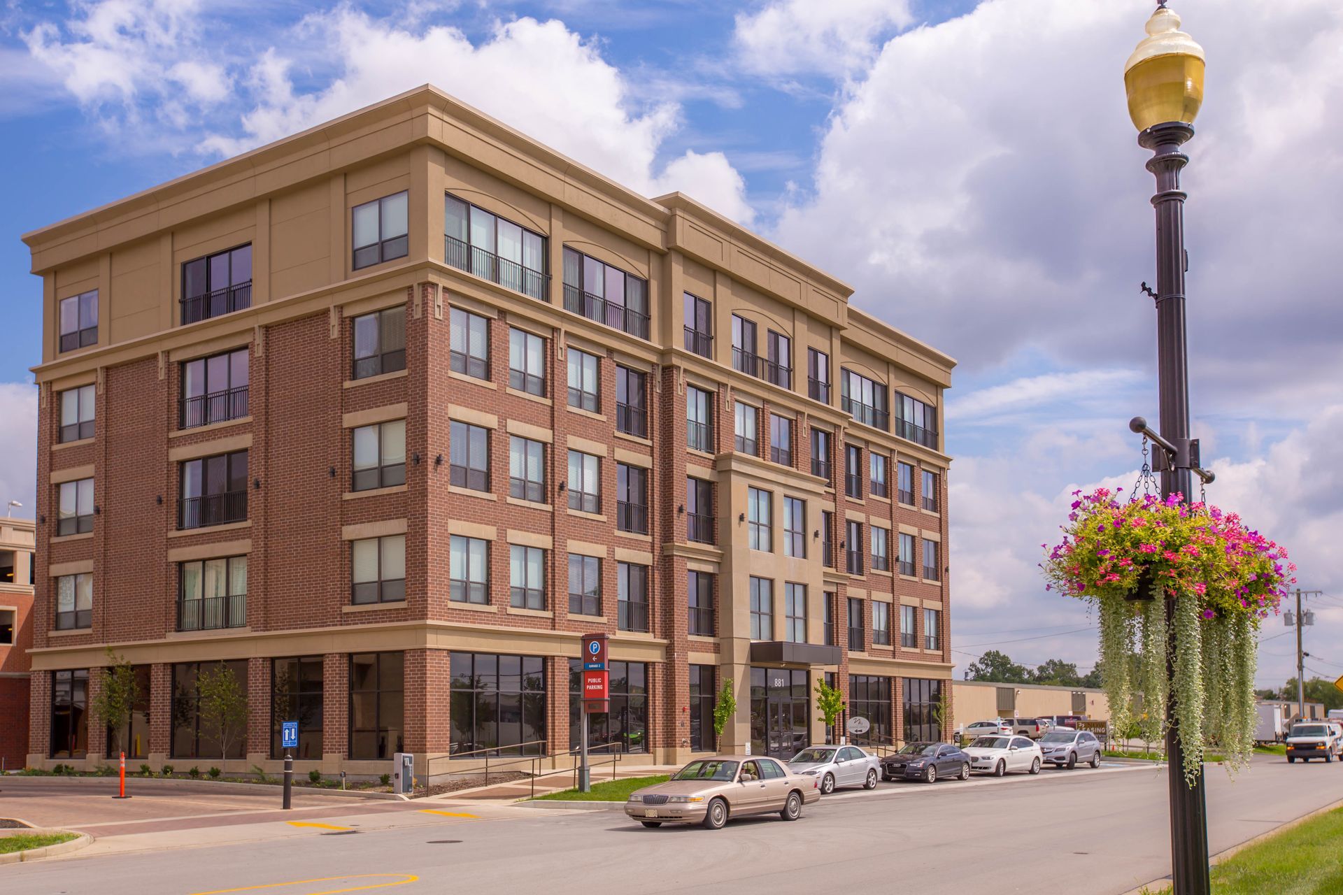 A large brick building with cars parked in front of it.