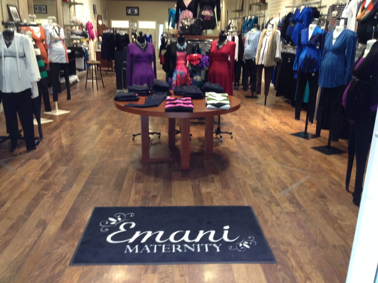 A store called emani maternity has a table with clothes on it