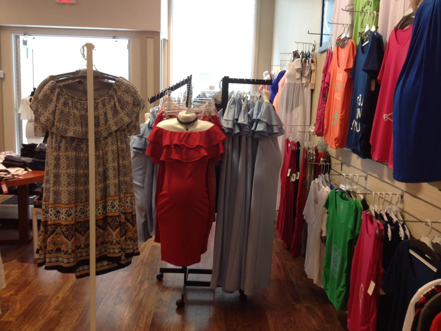 A red off the shoulder dress is on display in a clothing store