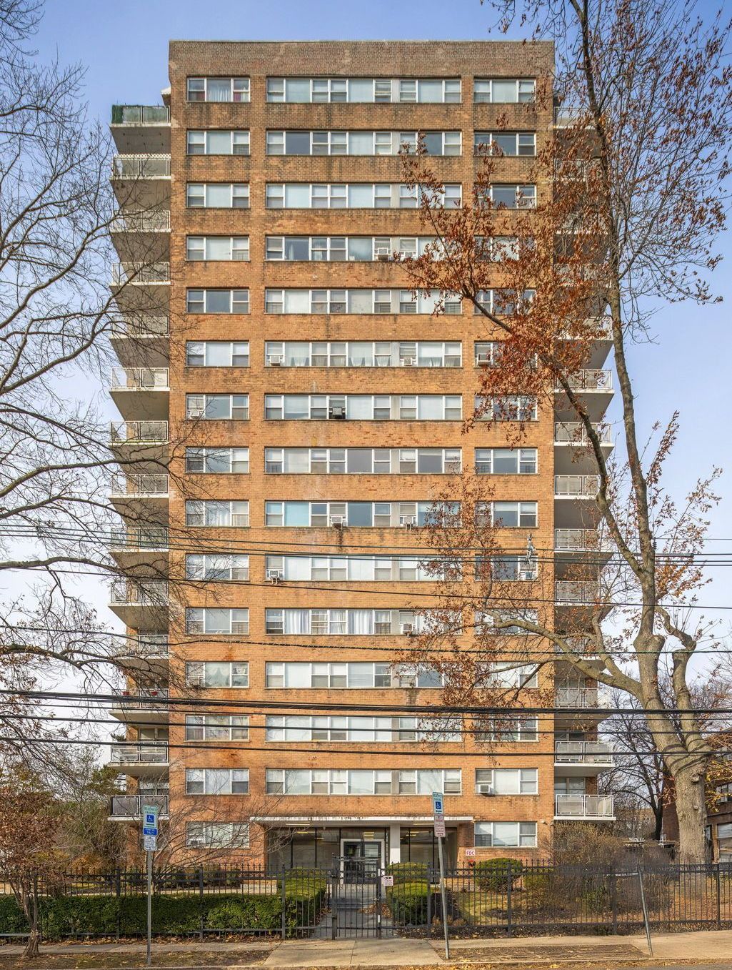 A tall brick building with lots of windows and balconies