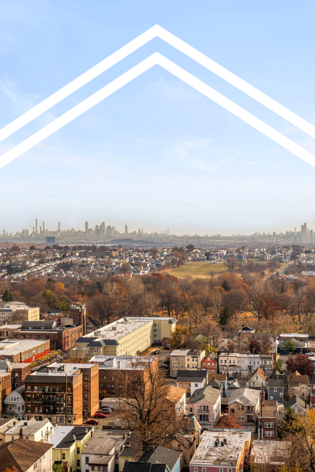 An aerial view of a city with a white arrow pointing to the sky.