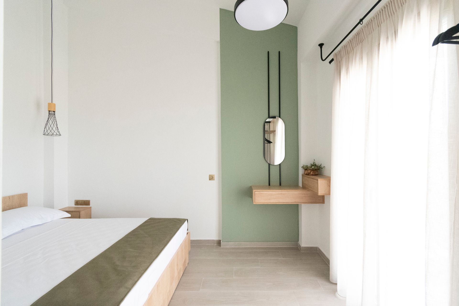 A bedroom with a bed and a mirror on the wall.