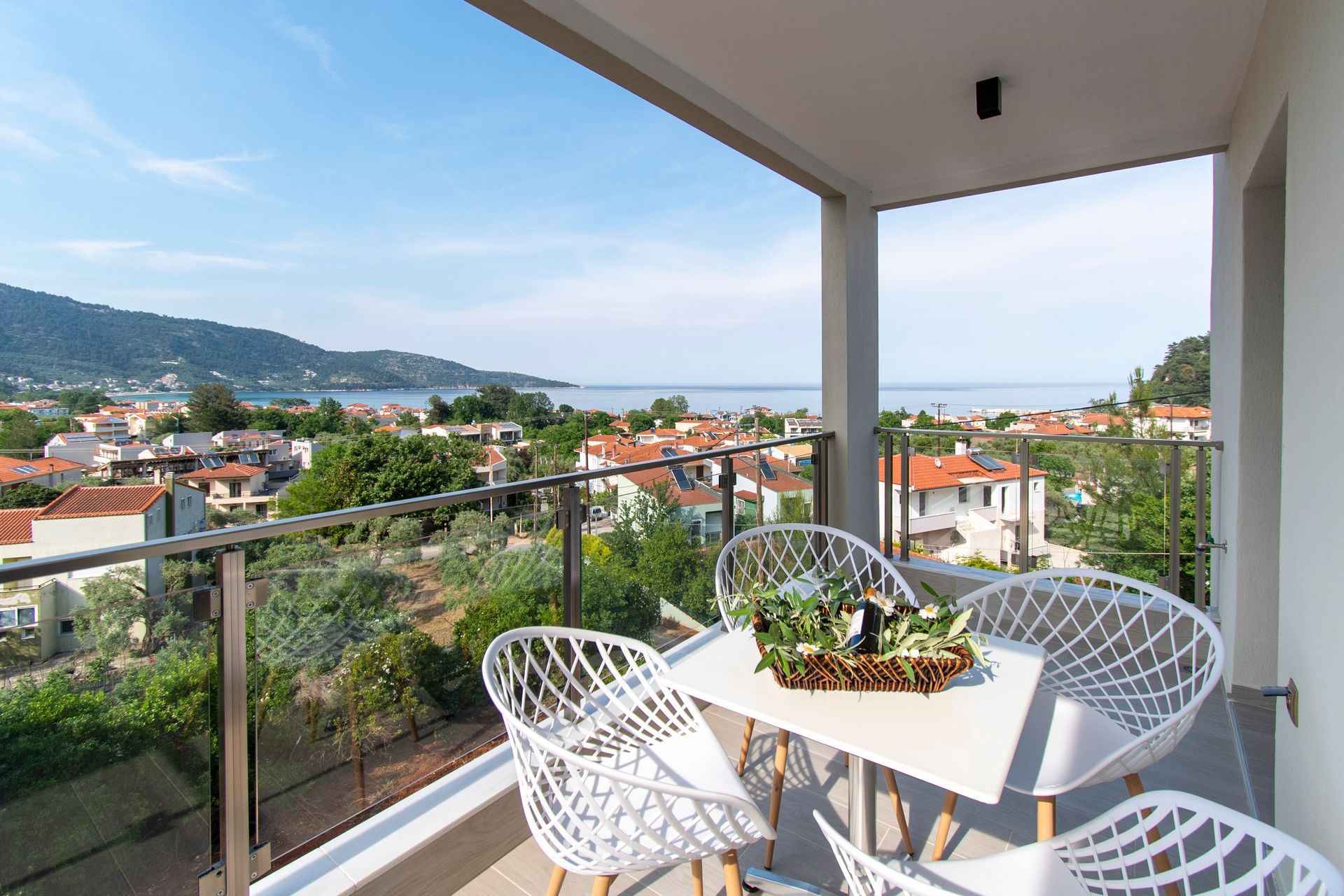 A balcony with a table and chairs and a view of the ocean.