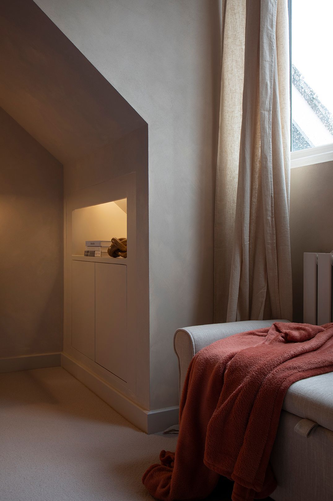 Custom built-in joinery under eaves with LED-lit niches and plaster walls — bespoke Watford bedroom renovation 