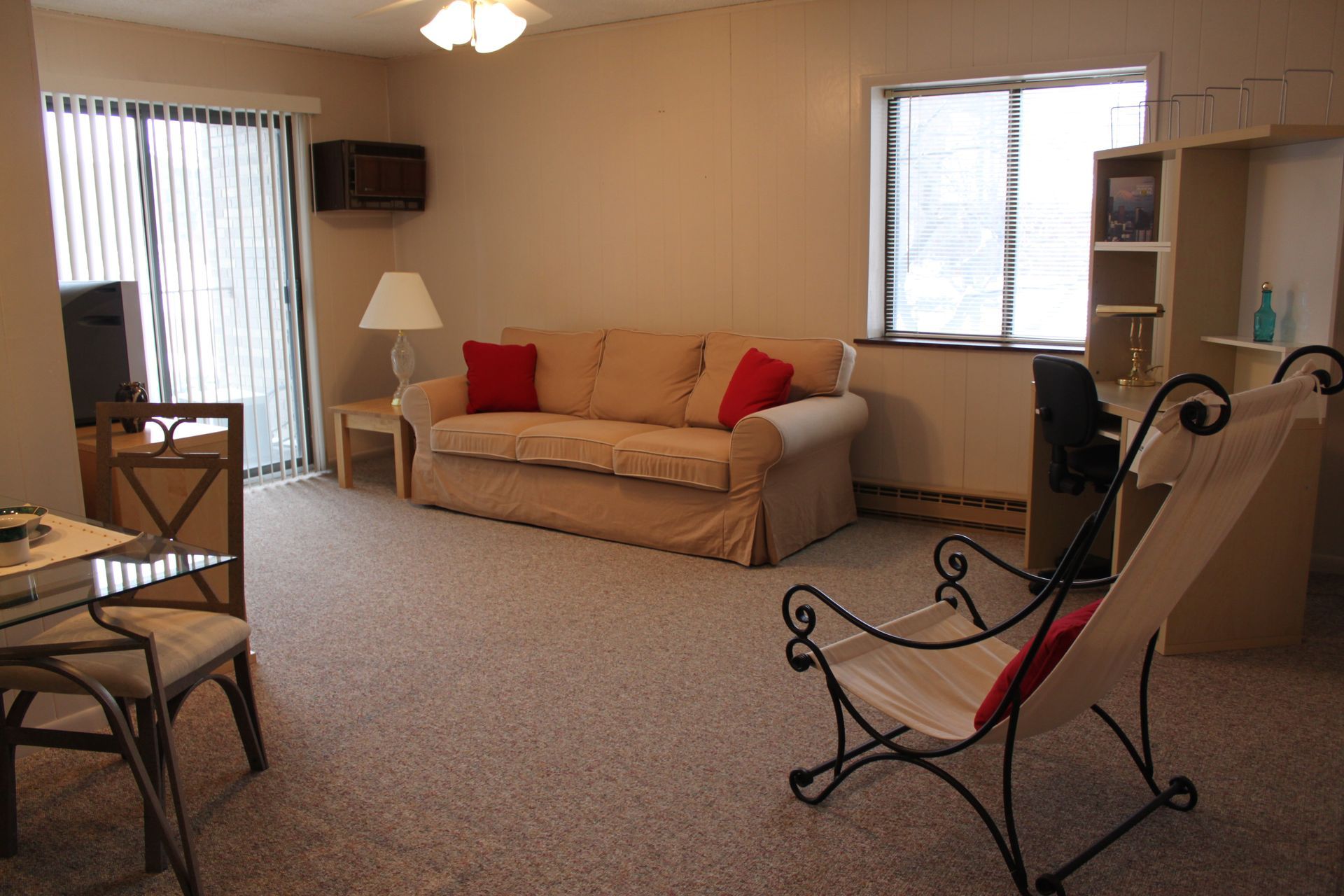 Photo showing a livingroom with plenty of natural lighting and glass patio doors