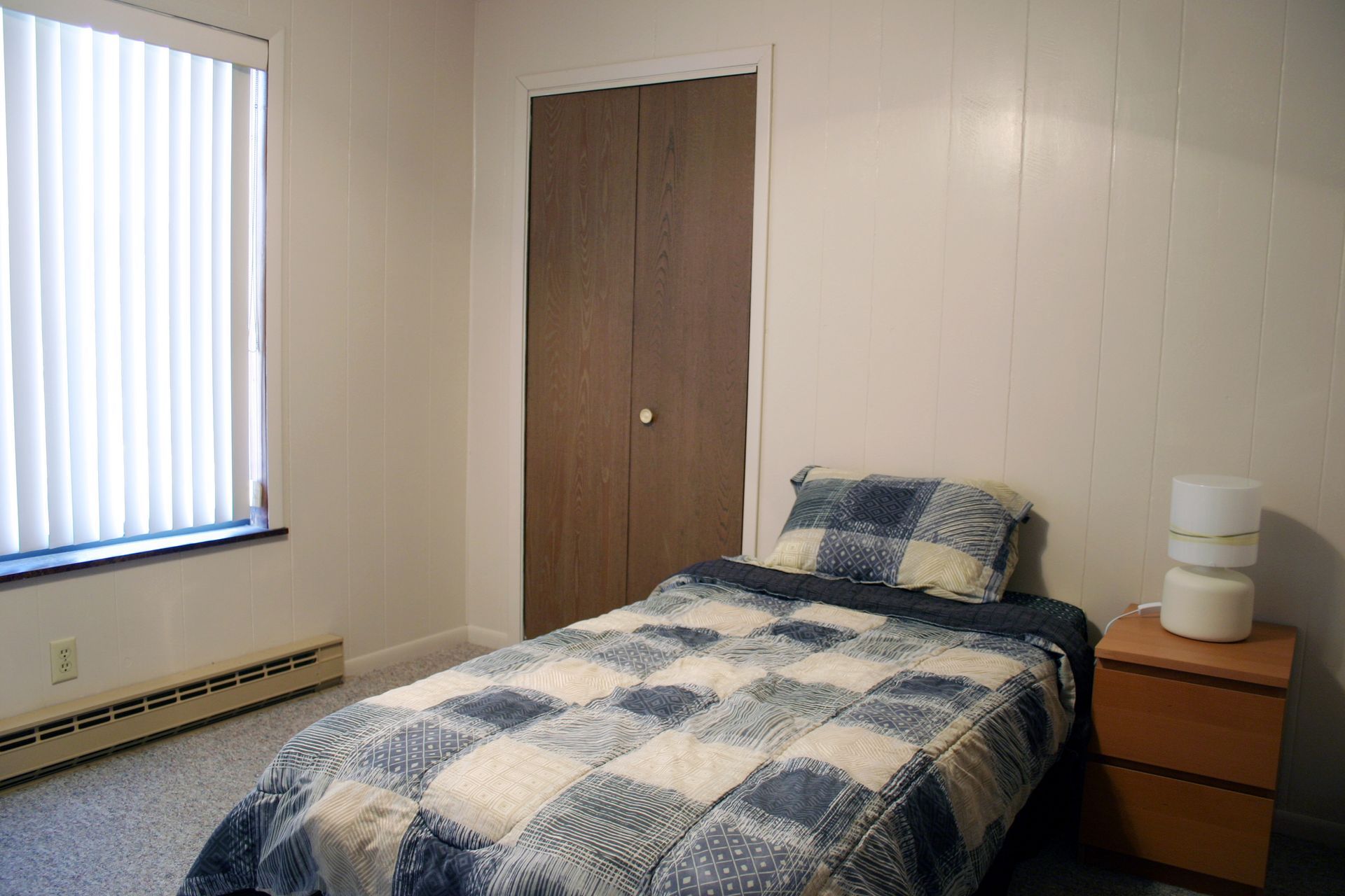 Photo showing a bed with a night stand next to it